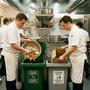 Cocina profesional de hotel con chefs separando residuos orgánicos en contenedores diferenciados