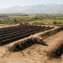 Vista aérea de planta de compostaje municipal con hileras paralelas en campo chileno y cordillera al fondo